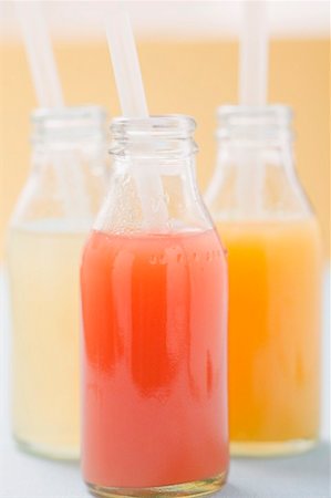 sweet fruits juice - Three fruit juices in bottles with straws Stock Photo - Premium Royalty-Free, Code: 659-02213297