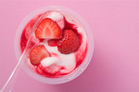 Strawberry yoghurt in plastic pot with spoon (overhead view) Stock Photo - Premium Royalty-Free, Code: 659-02213321
