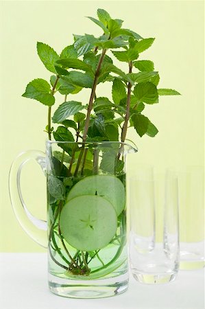 simsearch:659-03528496,k - Mint sprigs & cucumber slices in jug of water in front of glasses Foto de stock - Sin royalties Premium, Código: 659-02213401