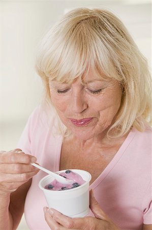 picture elderly people eating - Woman eating blueberry yoghurt Stock Photo - Premium Royalty-Free, Code: 659-02213415