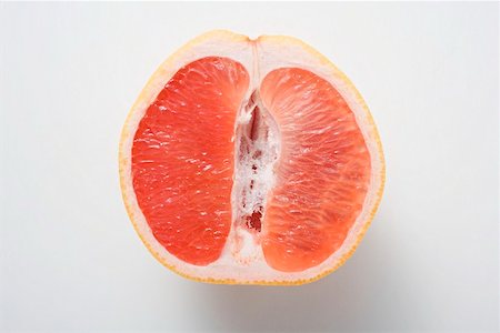 simsearch:659-02213454,k - Half a pink grapefruit (longitudinal section) Foto de stock - Sin royalties Premium, Código: 659-02213475