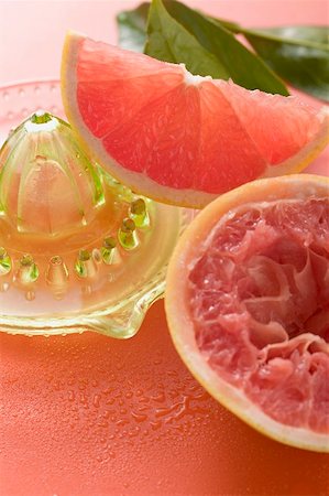 spremiagrumi a mano - Pink grapefruit wedge, squeezed grapefruit, citrus squeezer Fotografie stock - Premium Royalty-Free, Codice: 659-02213480