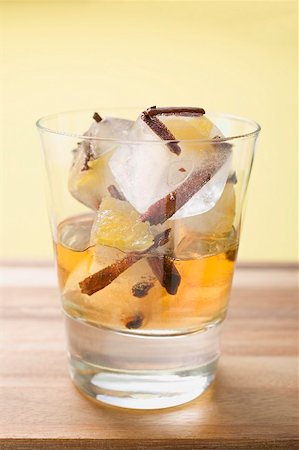 Rum and ice cubes with spices and pieces of fruit in glass Stock Photo - Premium Royalty-Free, Code: 659-02213497