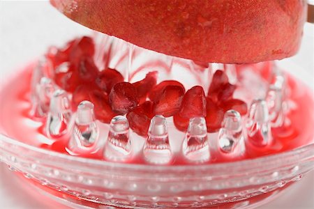 Squeezing a pomegranate Foto de stock - Royalty Free Premium, Número: 659-02213525