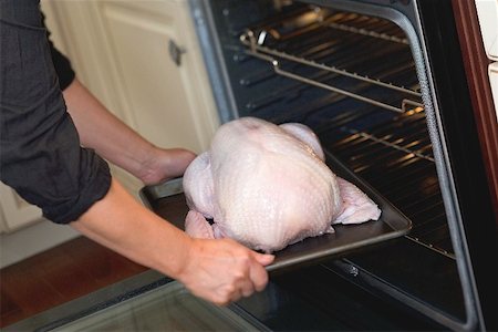 simsearch:659-01864909,k - Putting turkey on baking tray into oven Foto de stock - Royalty Free Premium, Número: 659-02213950