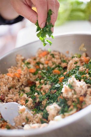 flat leaf parsley - Sprinkling parsley into bread stuffing Foto de stock - Sin royalties Premium, Código: 659-02213970