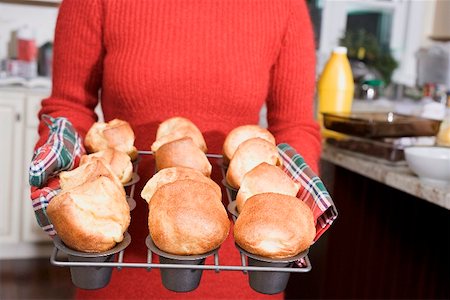 popovers - Woman holding freshly baked popovers on a rack Stock Photo - Premium Royalty-Free, Code: 659-02213995