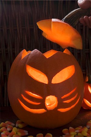 pumpkin carving - Hand putting lid on pumpkin lantern Stock Photo - Premium Royalty-Free, Code: 659-03524243