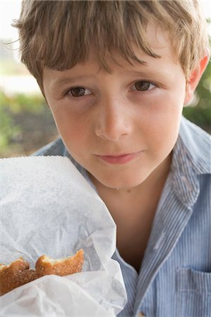 simsearch:659-01857446,k - Small boy holding a doughnut in paper Foto de stock - Sin royalties Premium, Código: 659-03524251