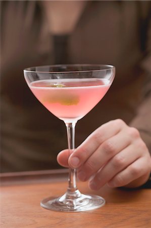 simsearch:659-03526561,k - Woman with glass of pink Martini with olive Foto de stock - Sin royalties Premium, Código: 659-03524393