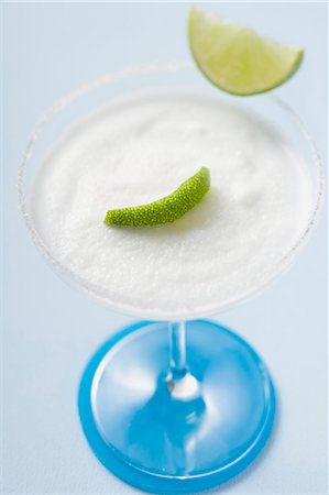 Margarita with lime wedges in a glass with a salted rim Stock Photo - Premium Royalty-Free, Code: 659-03524408