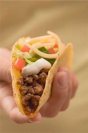 simsearch:659-02212587,k - Hand holding taco filled with mince and cheese Stock Photo - Premium Royalty-Free, Code: 659-03524445