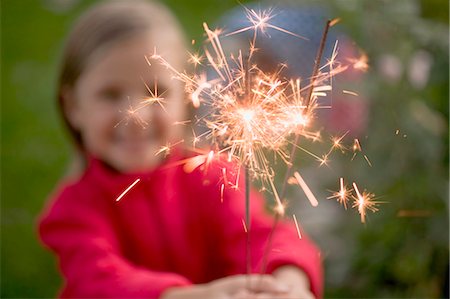 Small girl holding sparklers in garden Stock Photo - Premium Royalty-Free, Code: 659-03524443