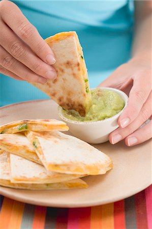 simsearch:659-03524467,k - Woman dipping piece of tortilla in guacamole Foto de stock - Royalty Free Premium, Número: 659-03524491