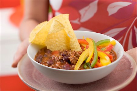 simsearch:659-06153153,k - Femme au service de chili con carne avec nachos et poivrons Photographie de stock - Premium Libres de Droits, Code: 659-03524527