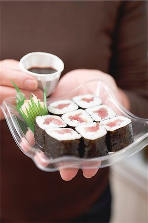 simsearch:659-02212373,k - Femme tenant des sushi maki et sauce de soja sur le plateau en plastique Photographie de stock - Premium Libres de Droits, Code: 659-03524574