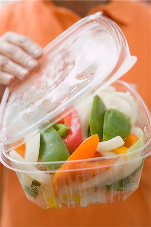 pictures of plastic container for cut vegetables - Woman holding plastic container of vegetables Stock Photo - Premium Royalty-Free, Code: 659-03524580