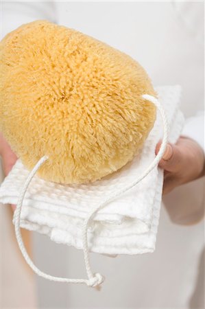 simsearch:659-03524635,k - Hands holding bath sponge on white towel Foto de stock - Royalty Free Premium, Número: 659-03524629