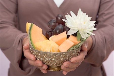 simsearch:659-01864546,k - Woman holding bowl of fresh fruit with water lily Stock Photo - Premium Royalty-Free, Code: 659-03524623