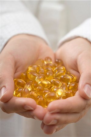 Hands holding vitamin capsules Stock Photo - Premium Royalty-Free, Code: 659-03524631