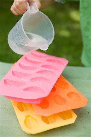 Child pouring water into ice cube tray Foto de stock - Sin royalties Premium, Código: 659-03524673