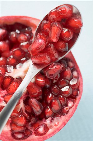 pomegranate cut up - Half a pomegranate and spoonful of pomegranate seeds Foto de stock - Sin royalties Premium, Código: 659-03524853