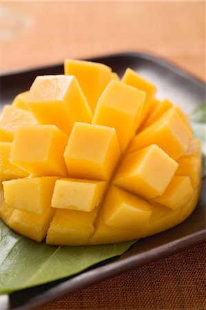 Diced mango still attached to the skin on brown plate Foto de stock - Sin royalties Premium, Código: 659-03524863