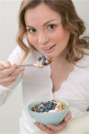 eat with cereal bowl with spoon - Woman eating muesli with blueberries Stock Photo - Premium Royalty-Free, Code: 659-03525012