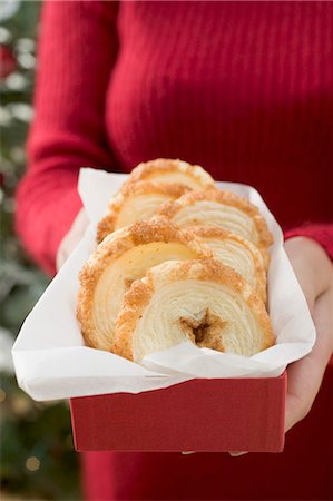 Woman holding palmiers (puff pastry biscuits) in box Stock Photo - Premium Royalty-Free, Code: 659-03525064