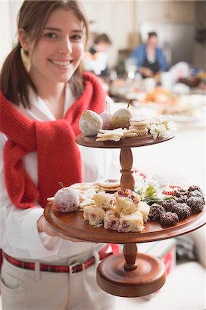 simsearch:659-01866689,k - Young woman holding tiered stand full of Christmas fancies Foto de stock - Royalty Free Premium, Número: 659-03525129