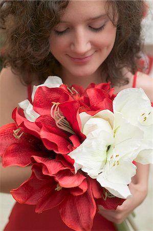 Woman holding red and white amaryllises Stock Photo - Premium Royalty-Free, Code: 659-03525250