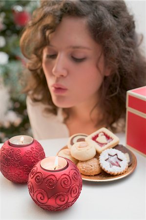 Woman blowing out tealights (Christmas) Fotografie stock - Premium Royalty-Free, Codice: 659-03525274