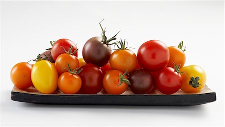 simsearch:659-03525278,k - Tomatoes of various colours on wooden plate Foto de stock - Royalty Free Premium, Número: 659-03525276