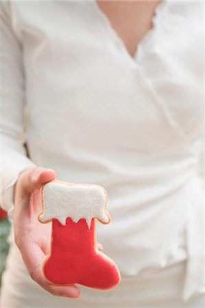 simsearch:659-01866689,k - Woman holding Christmas biscuit (red boot) Foto de stock - Royalty Free Premium, Número: 659-03525271