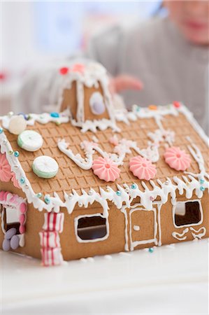 Child decorating gingerbread house with sugar pearls Stock Photo - Premium Royalty-Free, Code: 659-03525430