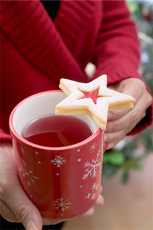 simsearch:659-03522727,k - Woman holding mug of tea with jam biscuit Foto de stock - Sin royalties Premium, Código: 659-03525448