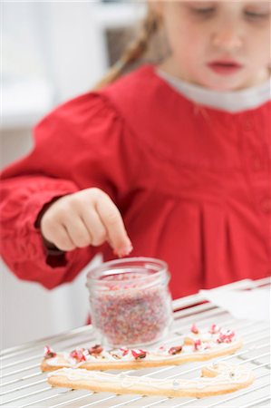 Small girl decorating Christmas biscuits Stock Photo - Premium Royalty-Free, Code: 659-03525440
