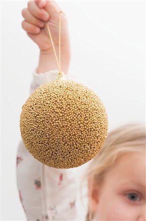 simsearch:659-03525502,k - Small girl holding gold Christmas bauble Foto de stock - Sin royalties Premium, Código: 659-03525459