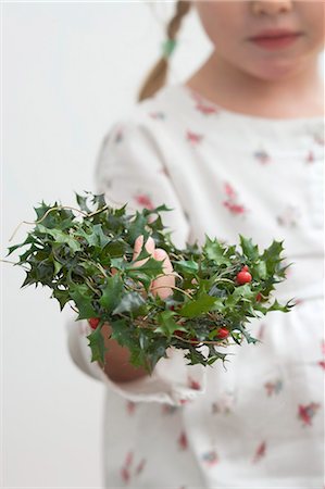 Small girl holding holly wreath Fotografie stock - Premium Royalty-Free, Codice: 659-03525450