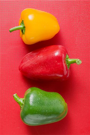 red bell pepper above - Different coloured peppers with drops of water on red background Stock Photo - Premium Royalty-Free, Code: 659-03525725