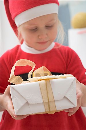 simsearch:659-03533706,k - Small girl in Father Christmas costume holding gift Stock Photo - Premium Royalty-Free, Code: 659-03525730