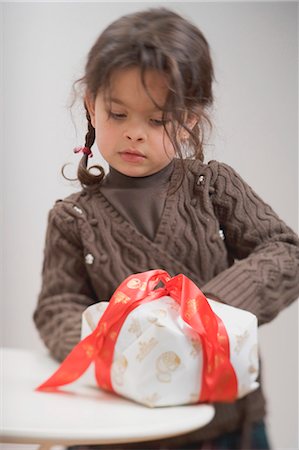 Small girl with cake in Christmas wrapping paper Stock Photo - Premium Royalty-Free, Code: 659-03525801