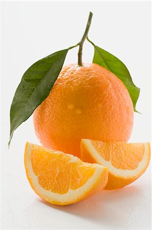Orange with stalk and leaf, orange wedges Stock Photo - Premium Royalty-Free, Code: 659-03525922