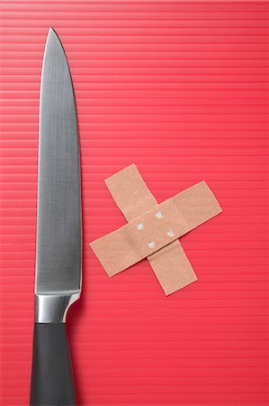 Knife and crossed sticking plasters on red background Foto de stock - Sin royalties Premium, Código: 659-03526379