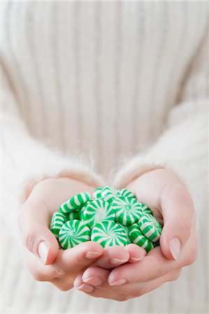 Hands holding green and white striped peppermints Stock Photo - Premium Royalty-Free, Code: 659-03526480