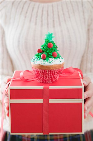 Woman holding cupcake on Christmas parcel Stock Photo - Premium Royalty-Free, Code: 659-03526481