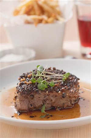 steak spice - Peppered steak with cress, chips in background Stock Photo - Premium Royalty-Free, Code: 659-03526571