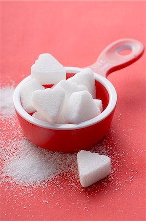 Heart-shaped sugar lumps in red measuring cup Foto de stock - Sin royalties Premium, Código: 659-03526610