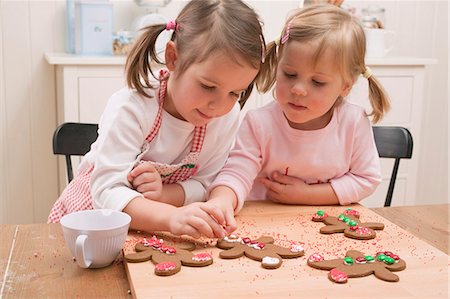 Two small girls decorating gingerbread men Stock Photo - Premium Royalty-Free, Code: 659-03526642