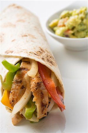 simsearch:659-03524467,k - Wrap filled with chicken and peppers, guacamole beside it Foto de stock - Royalty Free Premium, Número: 659-03526865